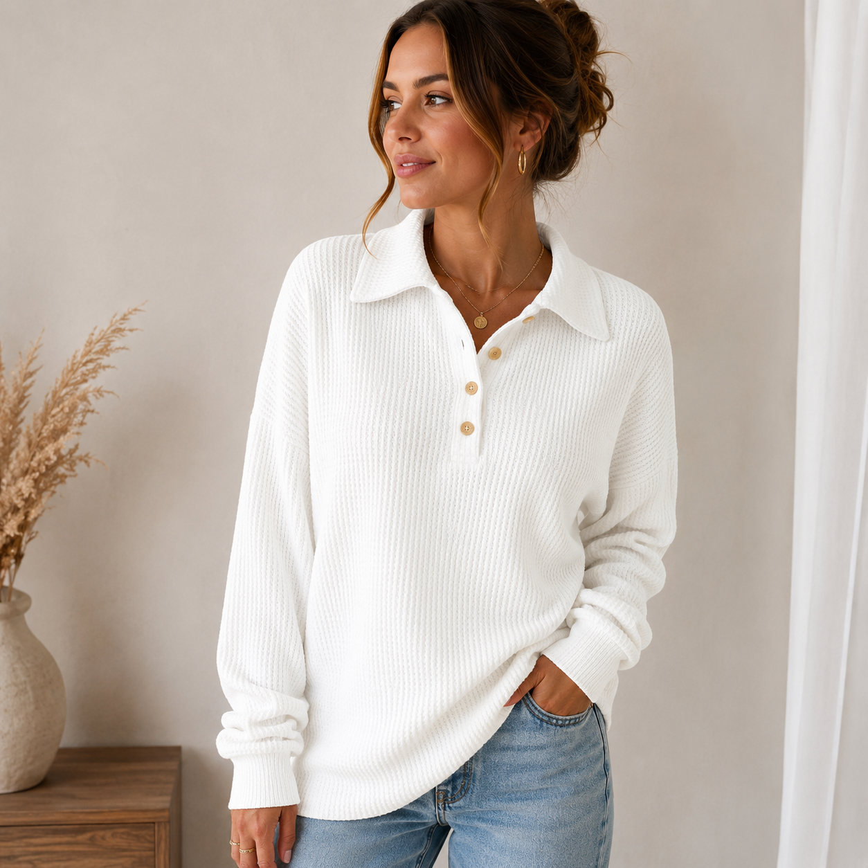 Woman wearing a white ribbed knit polo sweater featuring a button-front collar, long sleeves, and a comfortable relaxed fit.