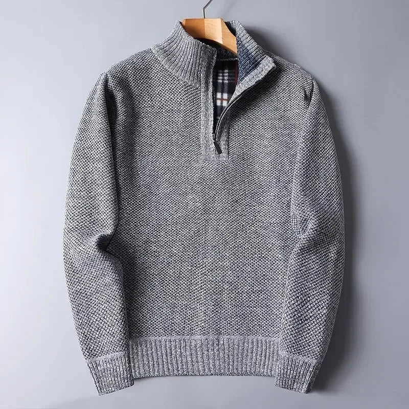 Grey heathered knit quarter-zip sweater with a mock neck, ribbed cuffs, and a plaid-lined interior on a wooden hanger.