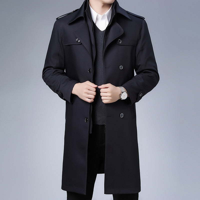Navy blue double-breasted trench coat with wide lapels, shoulder epaulettes, and a structured, tailored longline fit.