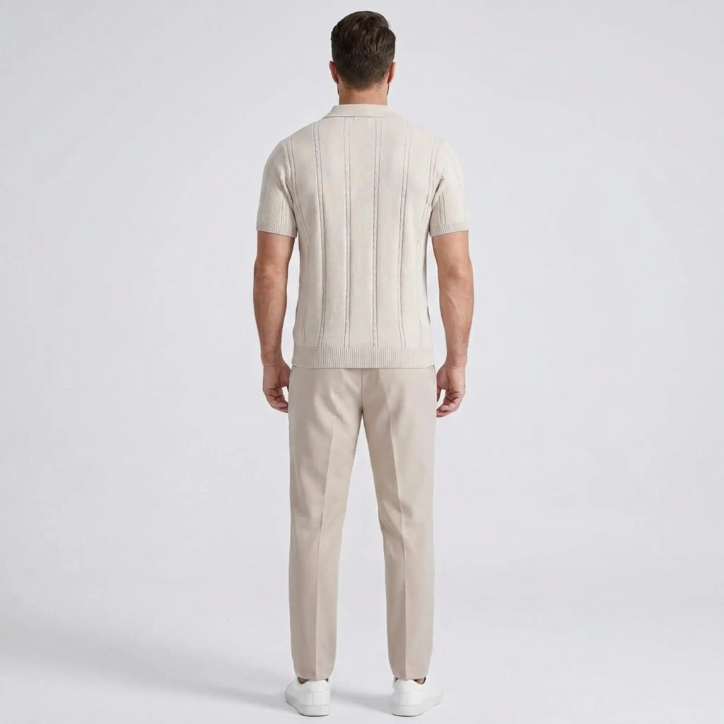 Back view of a man wearing a beige short-sleeve knit polo shirt with matching beige trousers.