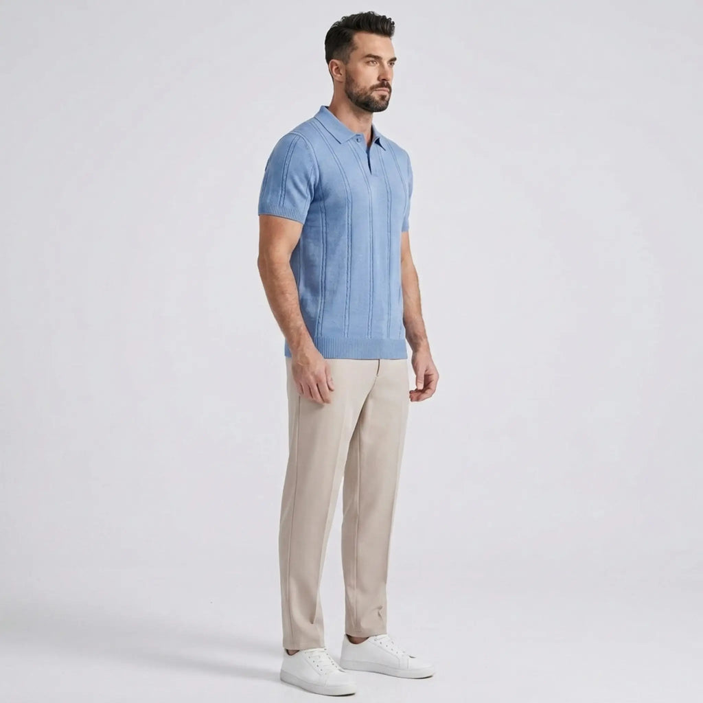 Side view of a man wearing a light blue knit polo shirt paired with beige trousers and white sneakers.
