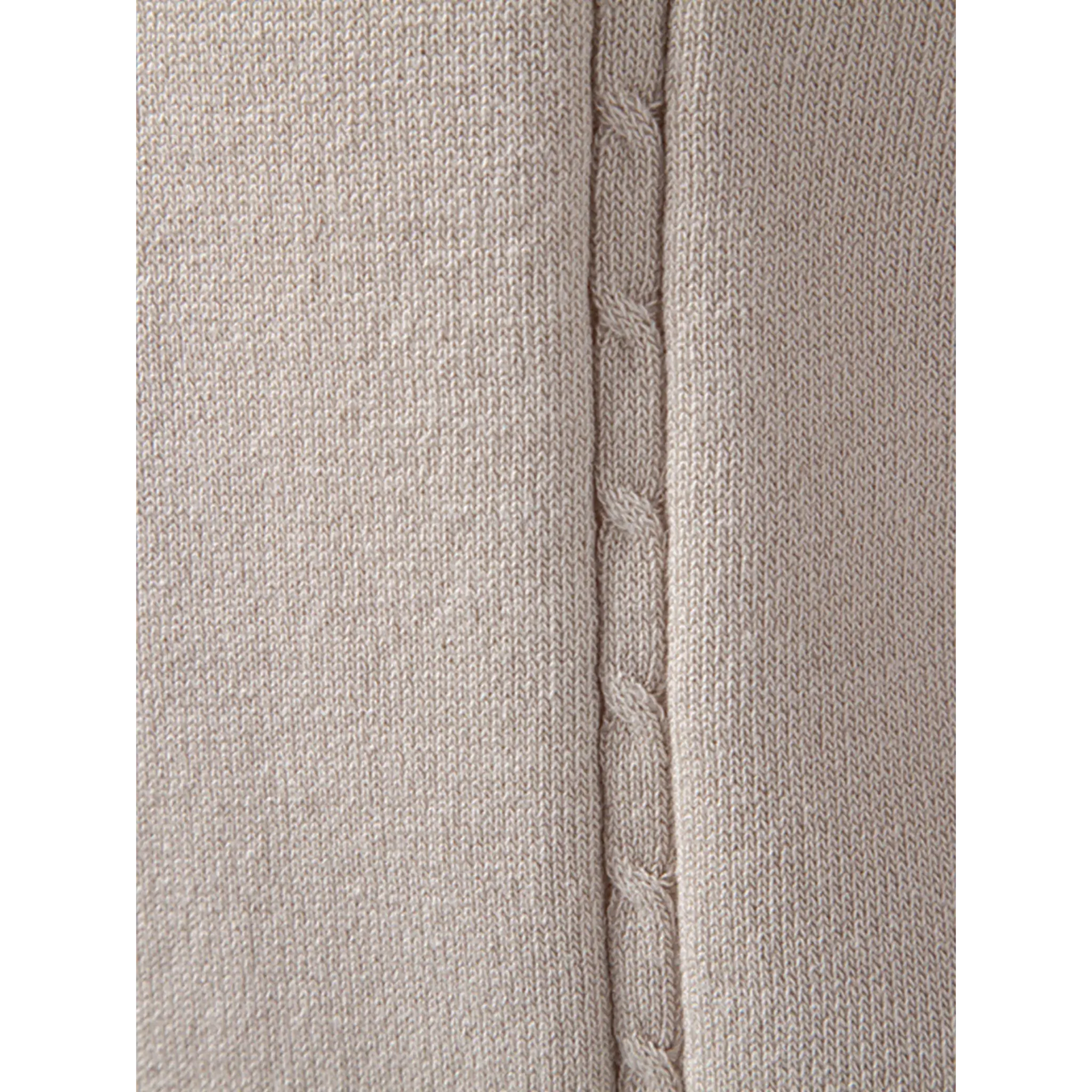 Close-up of the beige textured knit fabric highlighting the soft weave and premium finish.