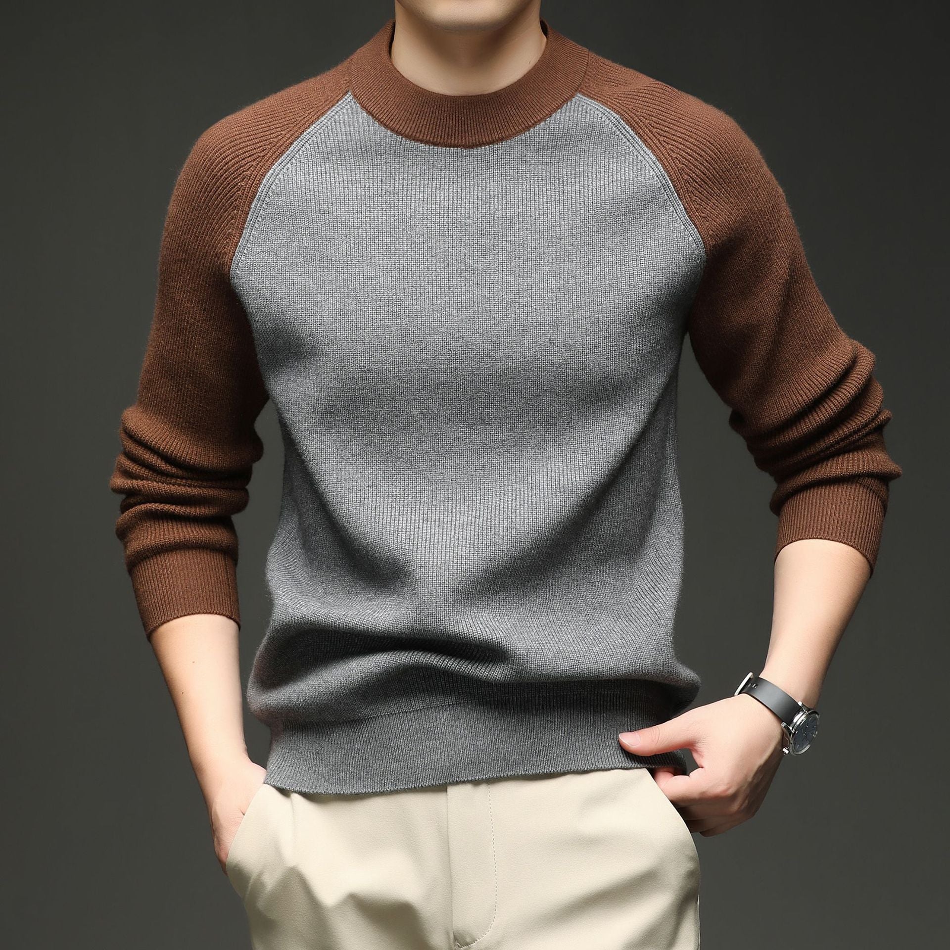 Man wearing grey and brown colorblock raglan knit sweater, close-up torso view
