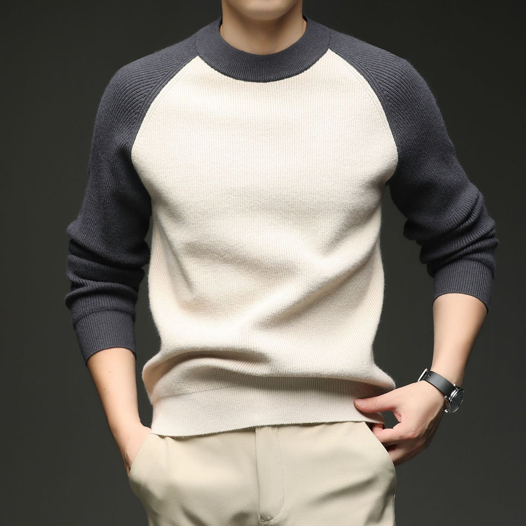Man wearing beige and charcoal colorblock raglan knit sweater, close-up torso view