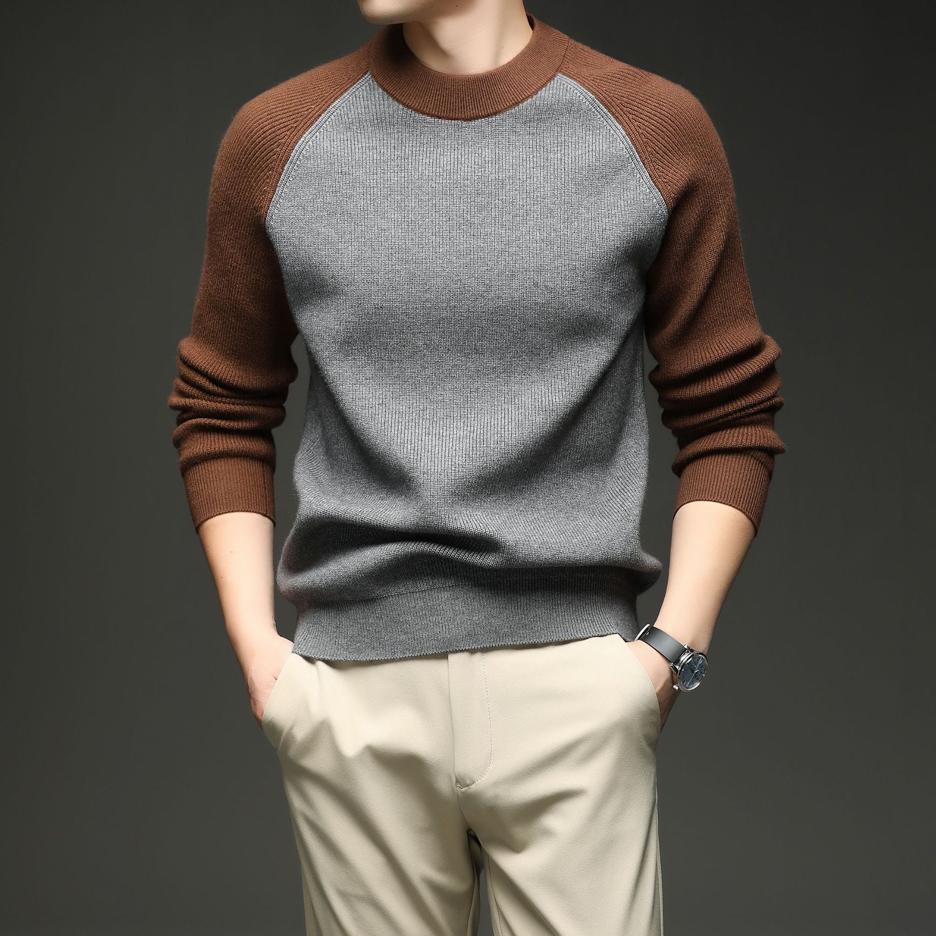 Man wearing grey and brown colorblock raglan knit sweater with hands in pockets, large front view