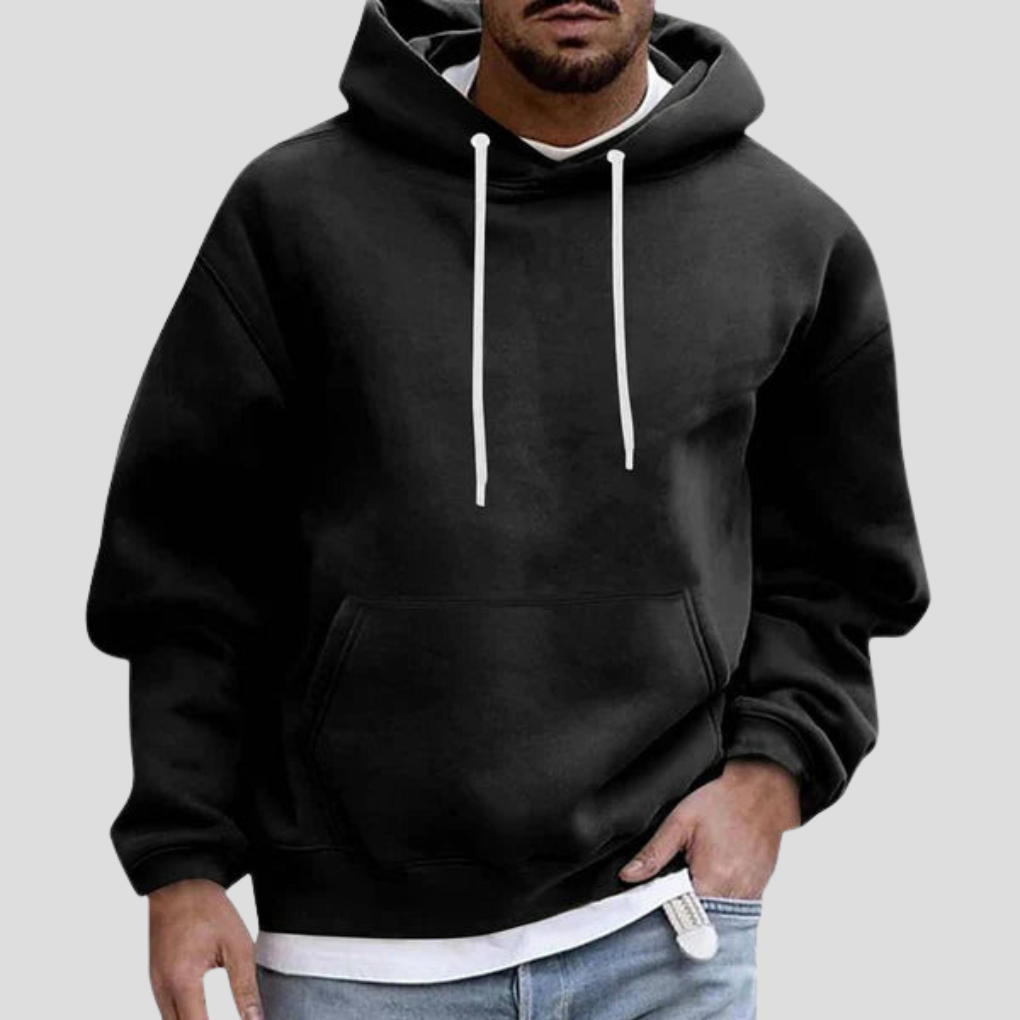 Black pullover hoodie on model, close-up front view with hand in pocket