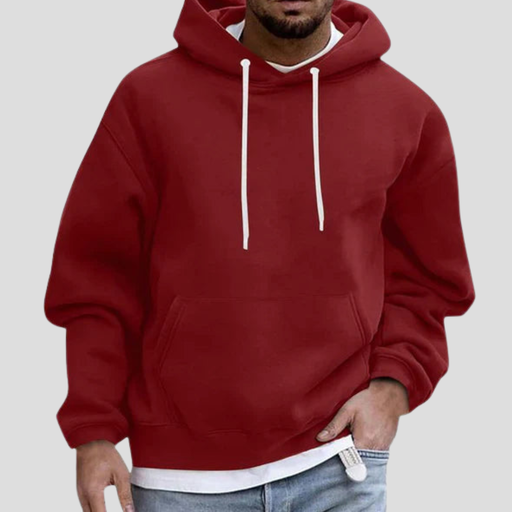 Burgundy pullover hoodie on model, close-up front view with hand in pocket