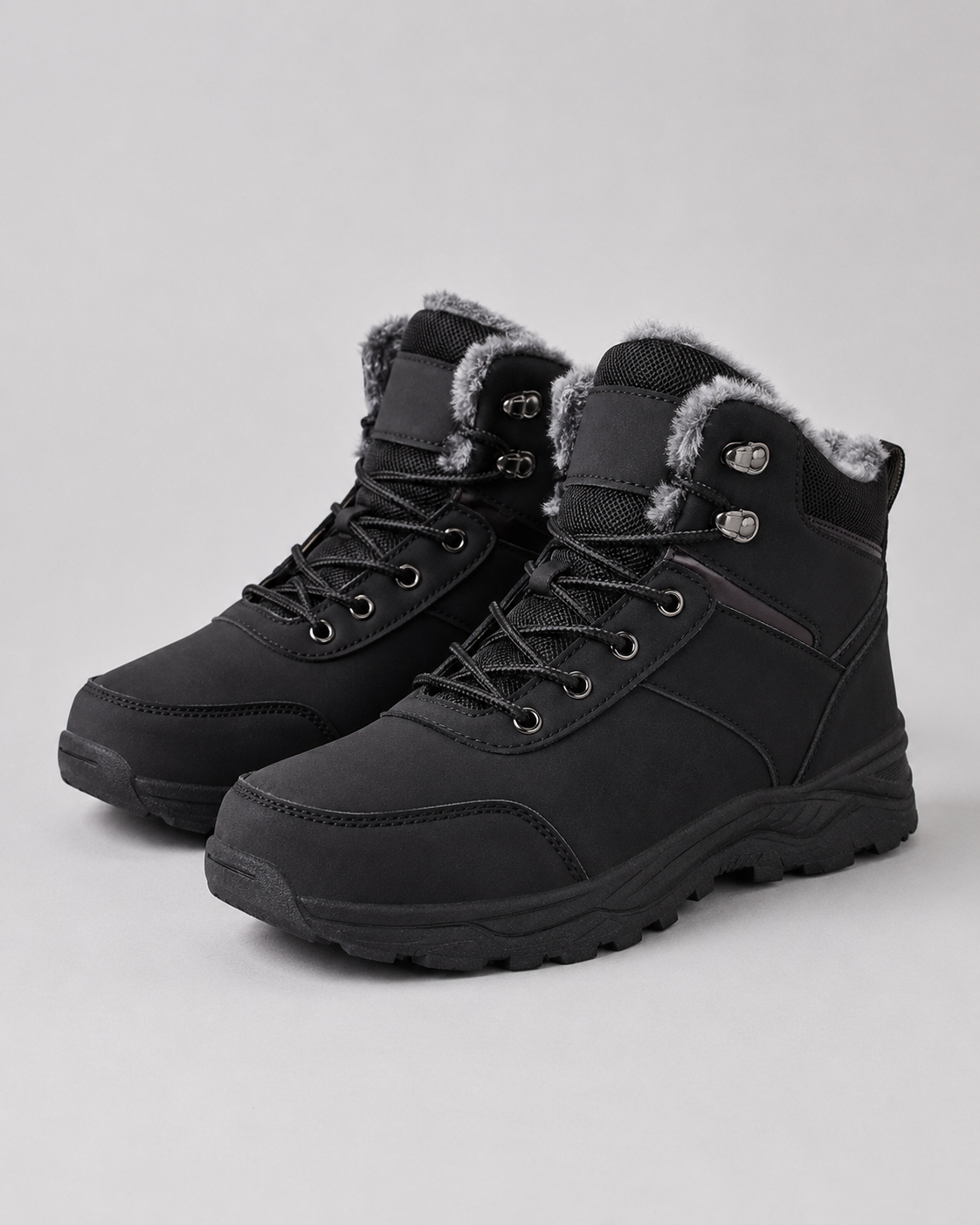 Black lug sole ankle boots with plush-lined collars and lace-up closures, shown in a three-quarter view