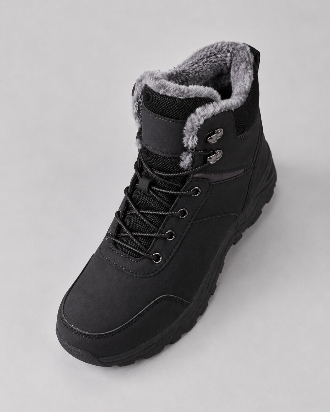 Black lug sole ankle boot with a plush-lined collar and lace-up closure, angled view