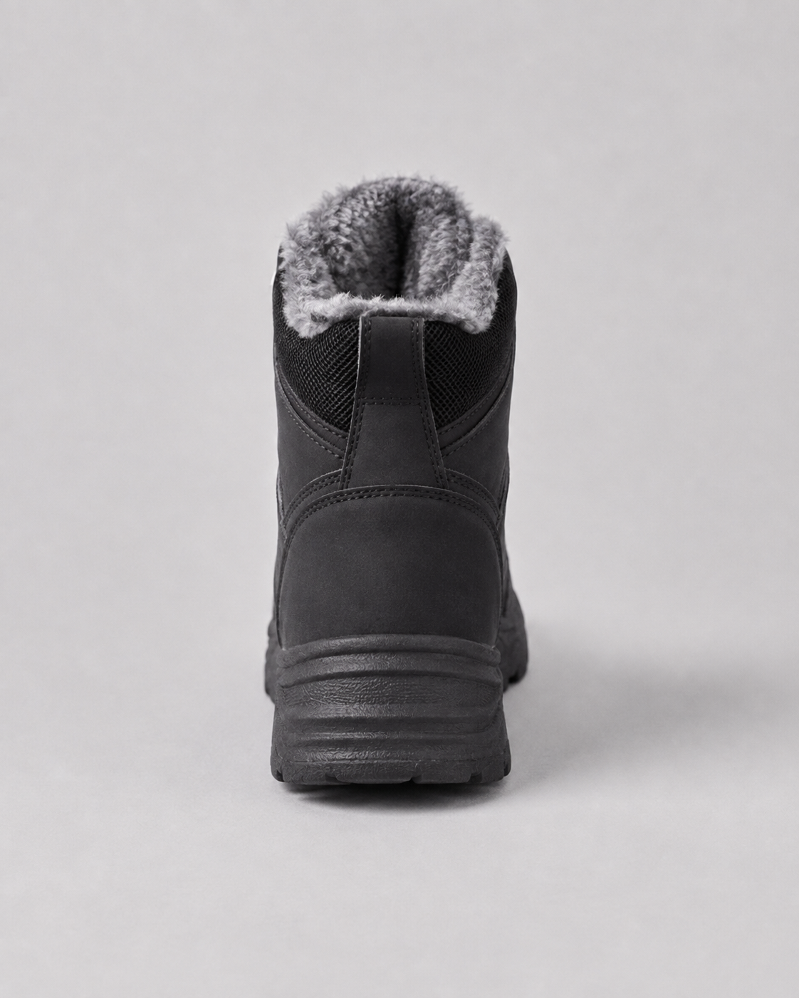 Black lug sole ankle boot with a plush-lined collar and lace-up closure, back view