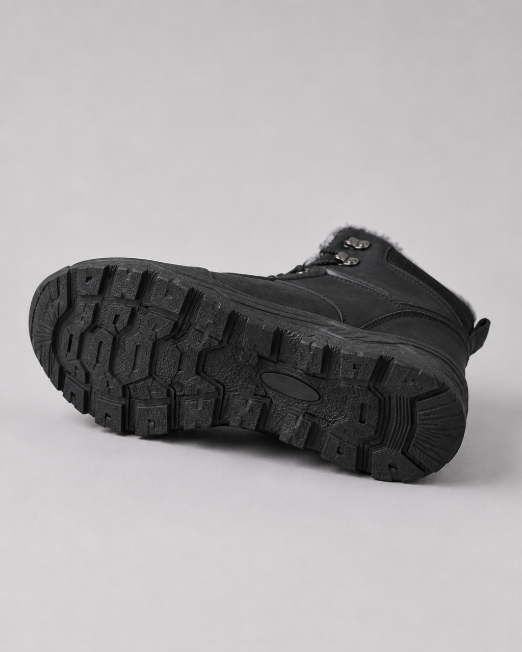 Black lug sole ankle boot showing the rugged treaded outsole and lace-up design