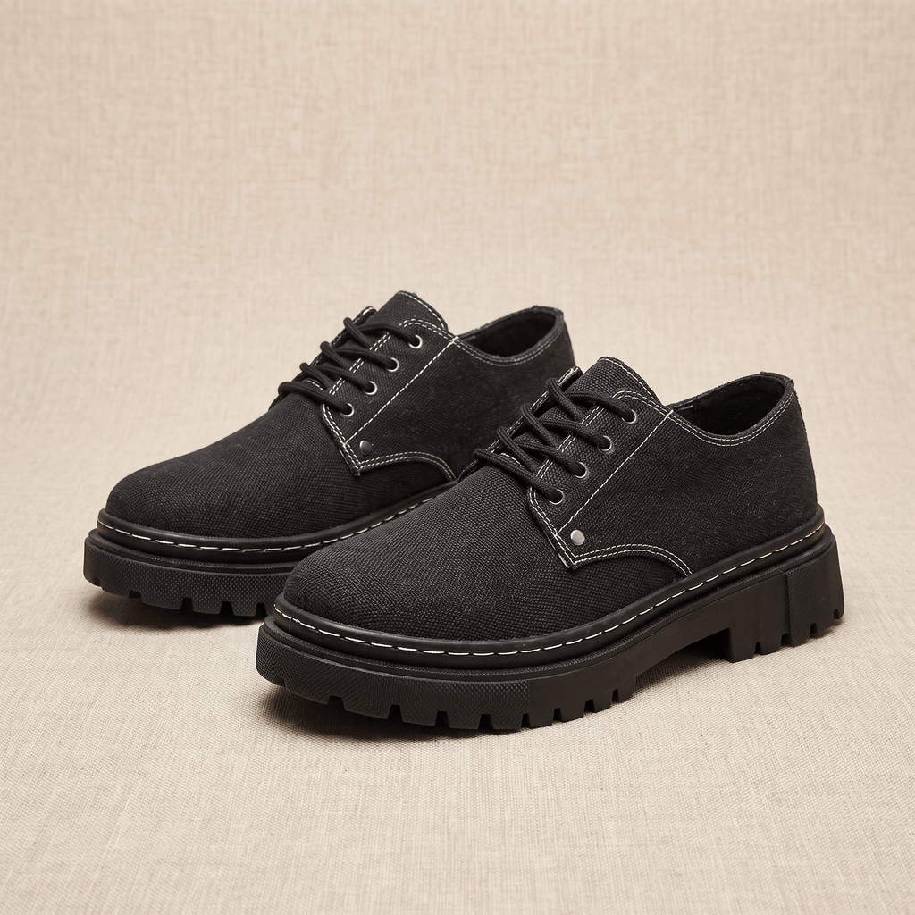 Pair of black denim Manuel lace-up shoes with white contrast stitching on beige backdrop