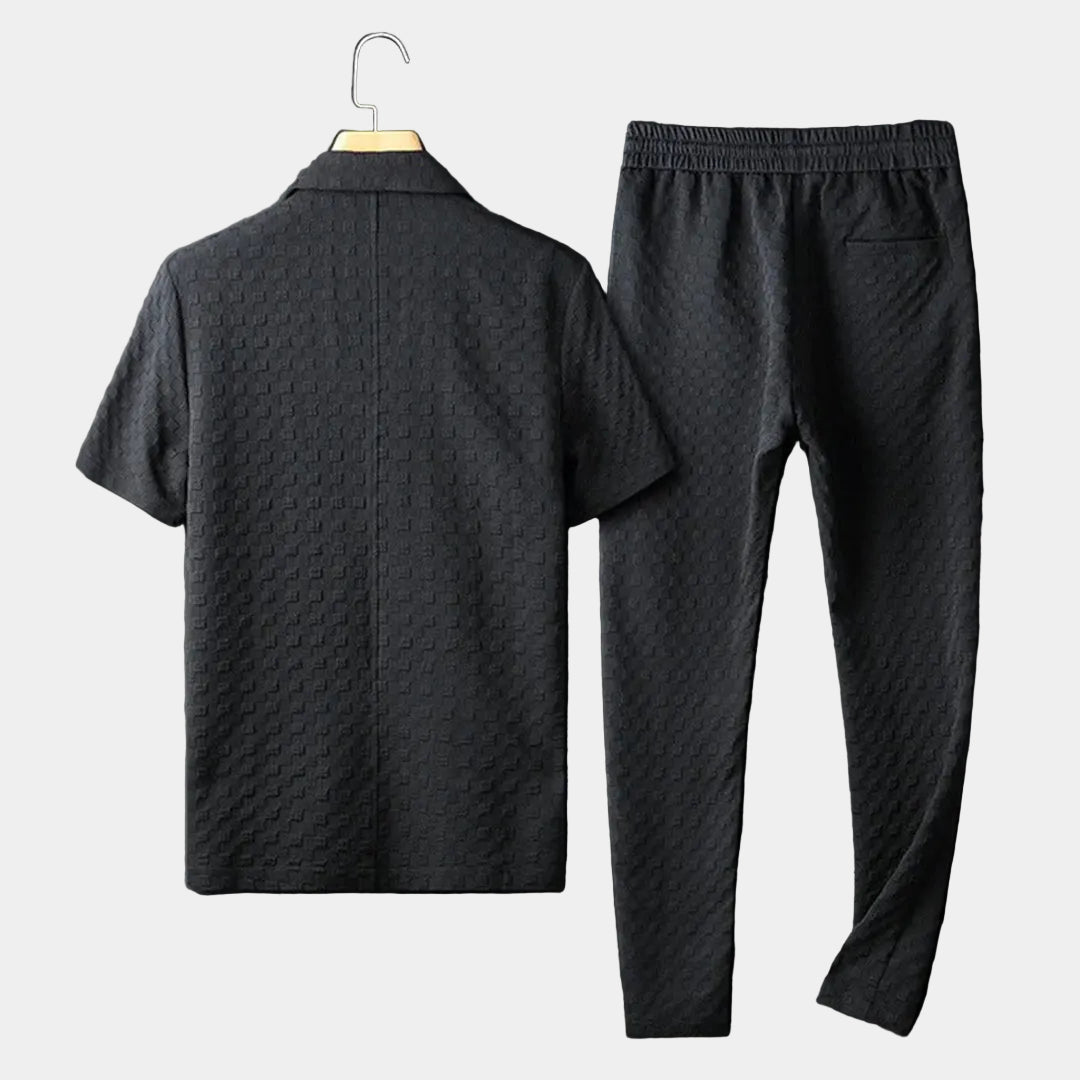 Back view of a men's black short-sleeve textured lounge shirt paired with matching drawstring pants.