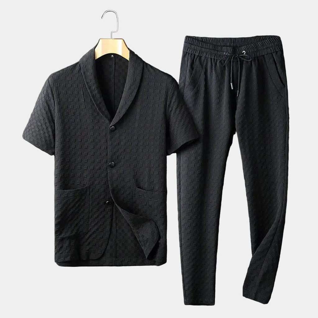 Men's black textured short-sleeve lounge shirt with matching drawstring pants displayed as a coordinated two-piece outfit.