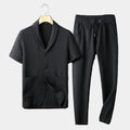 Men's black textured short-sleeve lounge shirt with matching drawstring pants displayed as a coordinated two-piece outfit.