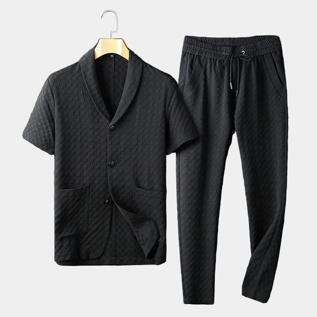 Men's black textured short-sleeve lounge shirt with matching drawstring pants displayed as a coordinated two-piece outfit.