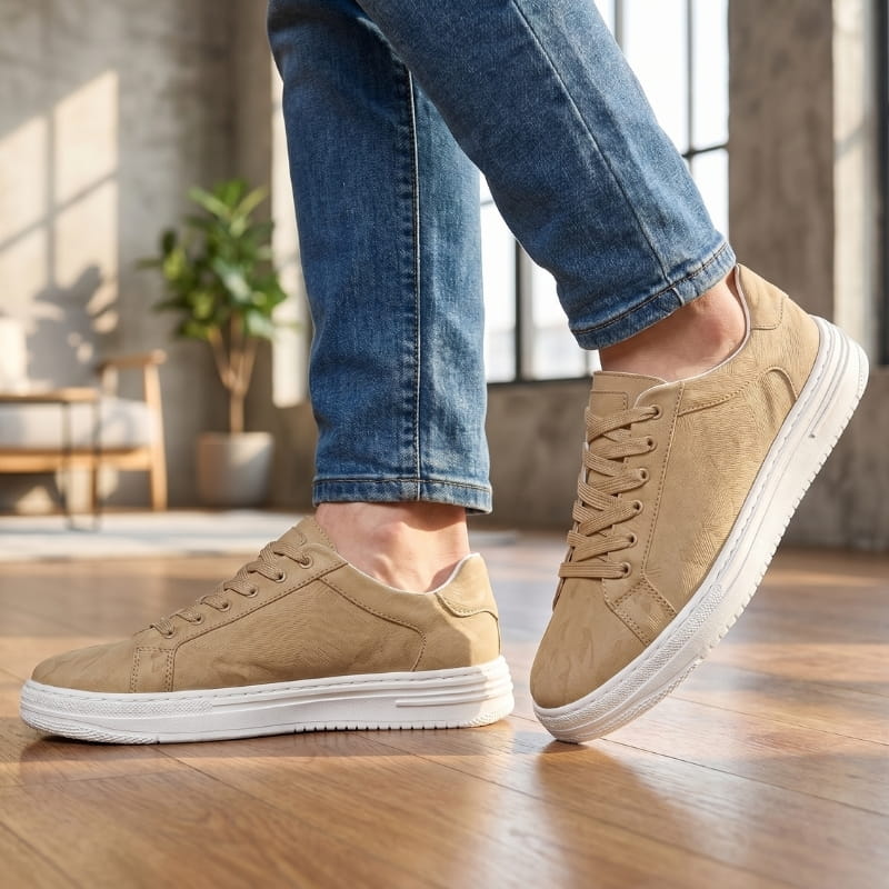 Person wearing beige leather sneakers with jeans, walking on a wood floor in a loft-style interior