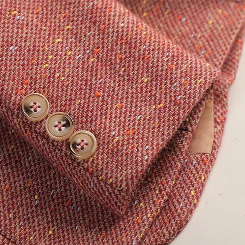 Close-up of the pink tweed blazer sleeve showing the textured fabric and decorative button cuff.