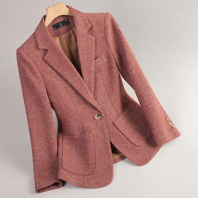 Women's pink tweed blazer with a notched lapel, single-button closure, flap pockets, long sleeves, and tailored silhouette.
