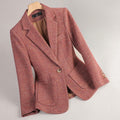 Women's pink tweed blazer with a notched lapel, single-button closure, flap pockets, long sleeves, and tailored silhouette.