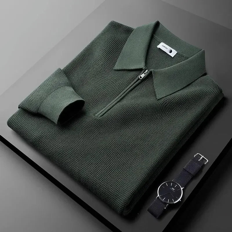 Olive green textured half-zip polo sweater with a ribbed collar and long sleeves, folded on a dark surface.