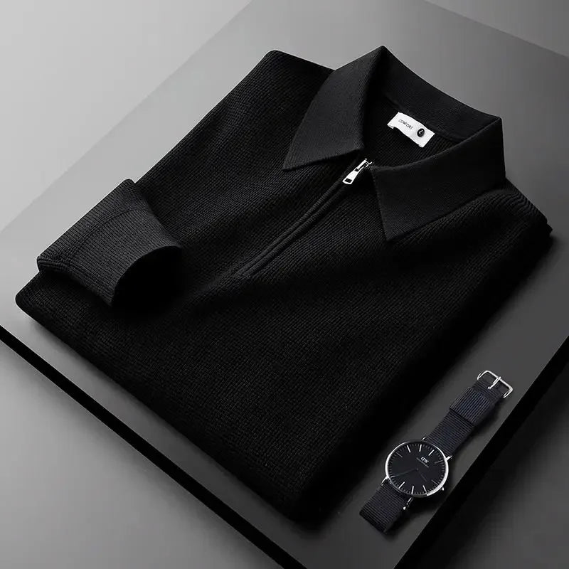 Black textured half-zip polo sweater featuring a ribbed collar and long sleeves, folded on a dark surface.
