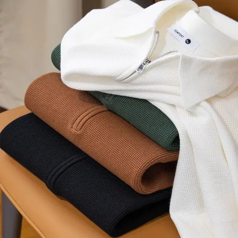 Folded textured half-zip polo sweaters in white, brown, olive green, and black, stacked together to showcase available color options.