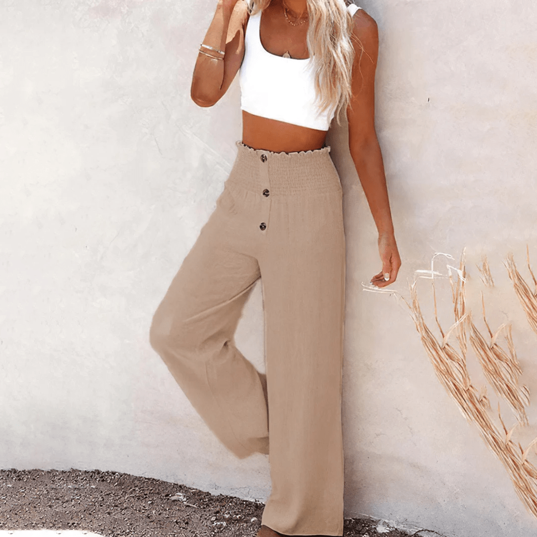 Women's beige high-waisted wide-leg linen pants with decorative front buttons, a relaxed silhouette, and side pockets.