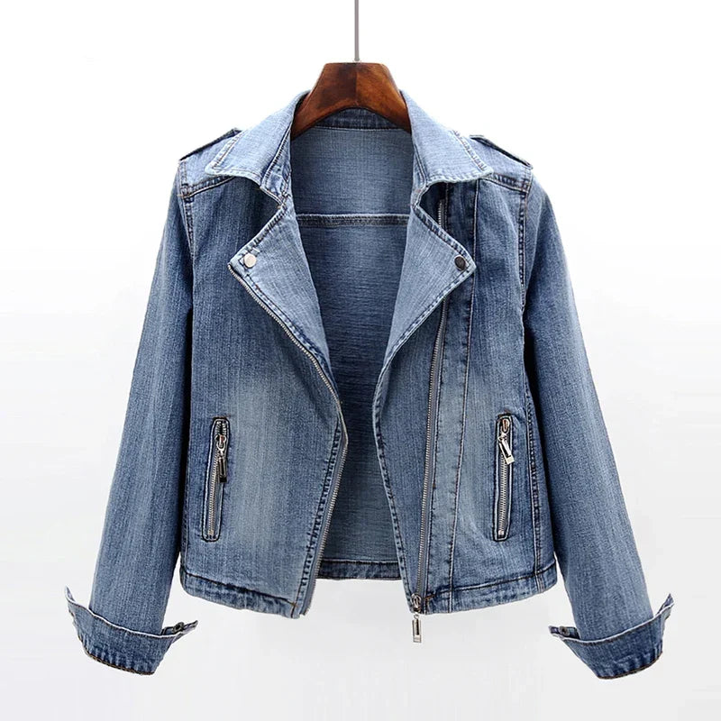 Women's blue denim moto jacket featuring an asymmetrical zip closure, notched lapel collar, zippered pockets, and rolled cuffs.
