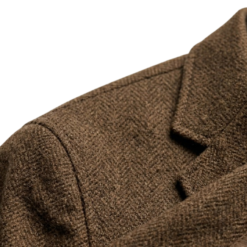 Close-up of the brown textured wool blazer showing the stand collar, shoulder seam, and structured fabric.