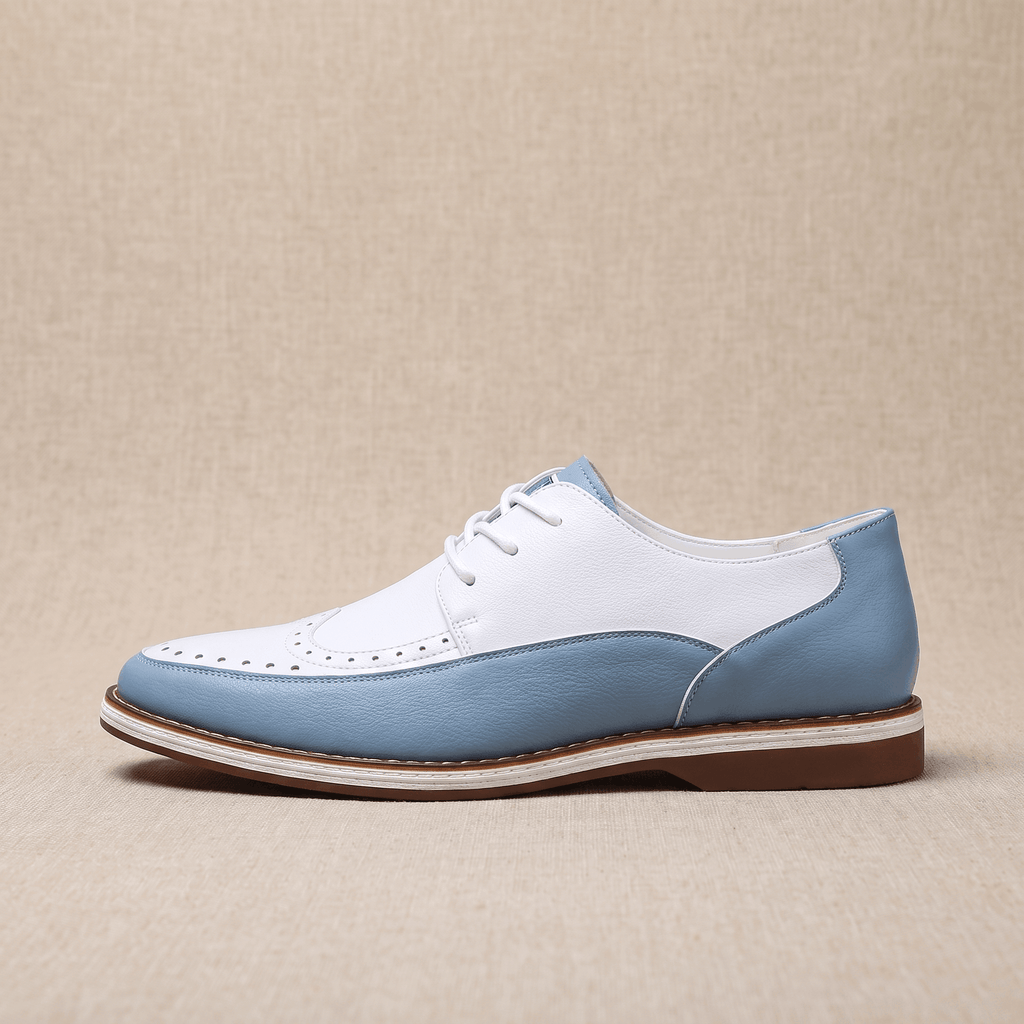 Side view of a single white and blue two-tone leather Mauro brogue with moc-toe seam, resting on a beige surface