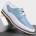 Single white and blue two-tone leather Mauro brogue with perforated wingtip detailing, angled on a white block against a studio backdrop