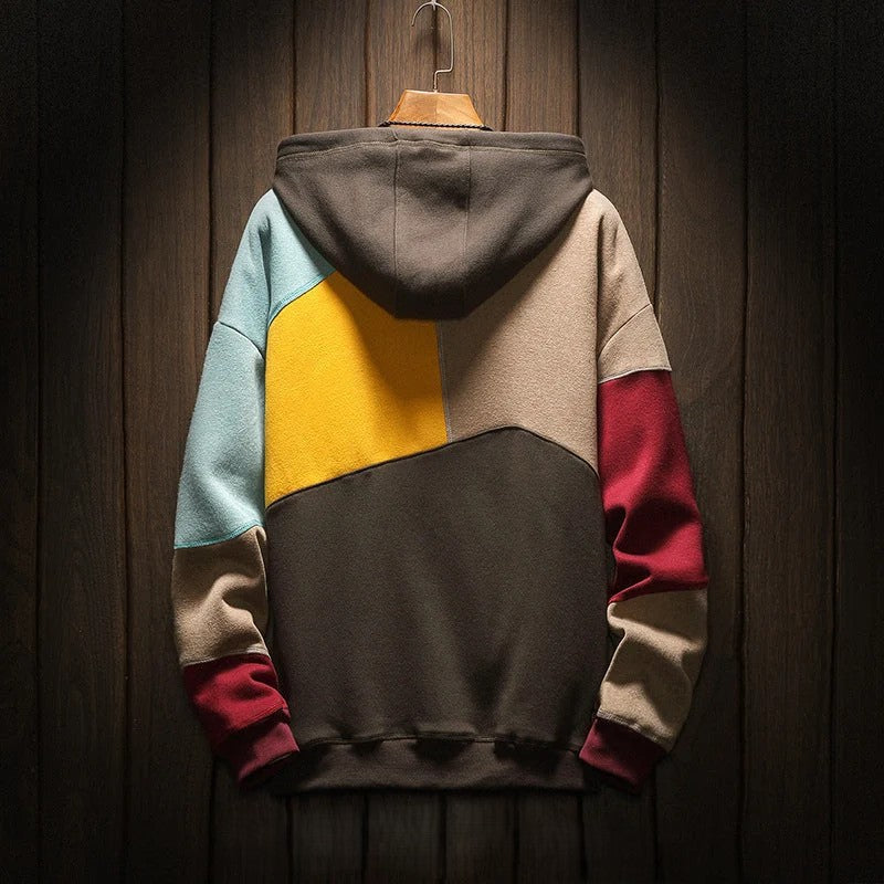 Colorblock hooded sweatshirt on wooden hanger, close-up back view against dark wood background