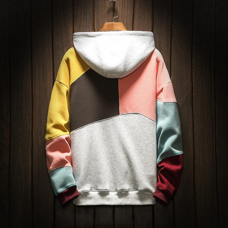 Colorblock hooded sweatshirt on wooden hanger, close-up back view against dark wood background