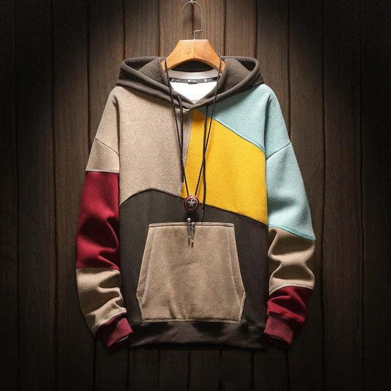 Colorblock hooded sweatshirt with kangaroo pocket on wooden hanger, full front view against dark wood background