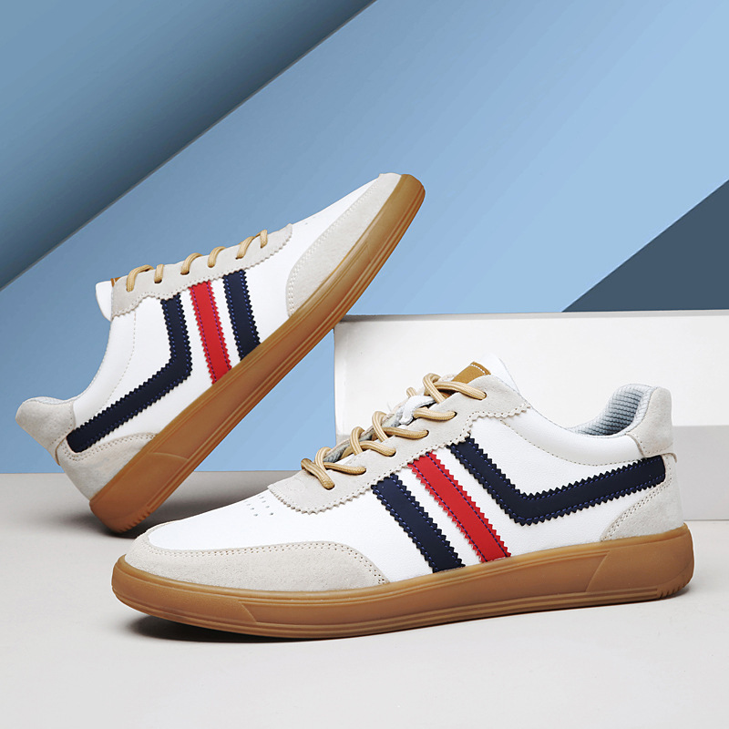 Pair of white leather retro court sneakers with navy and red stripes stacked at an angle on a blue gradient background