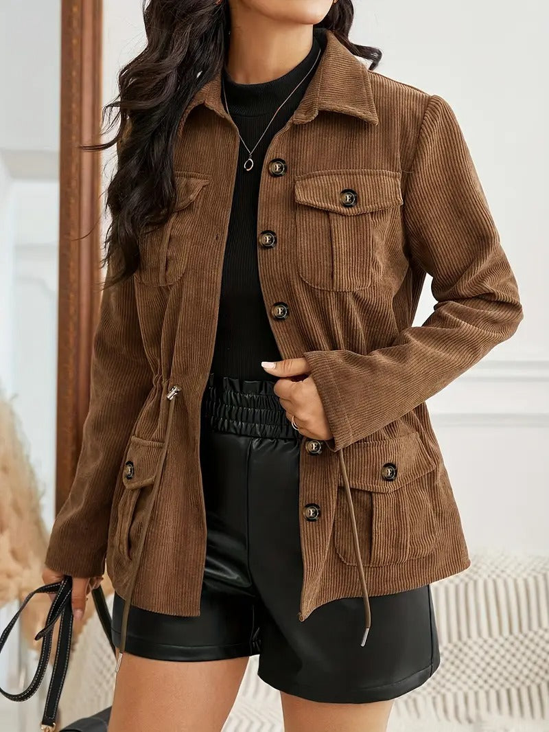 Woman posing in the brown utility jacket, showing the structured fit, chest pockets, and adjustable waist.