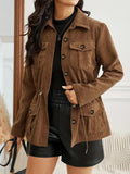 Woman posing in the brown utility jacket, showing the structured fit, chest pockets, and adjustable waist.