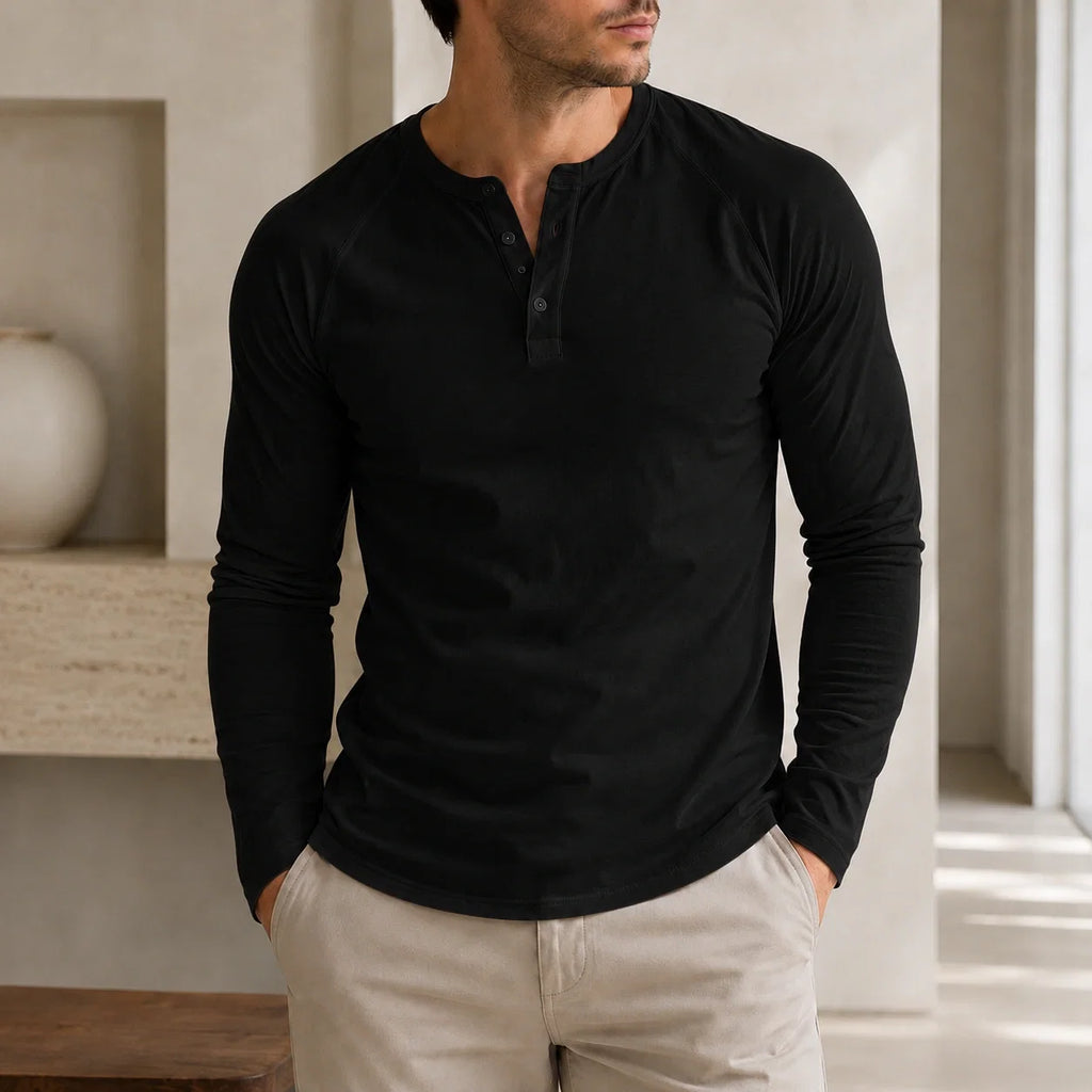 Man wearing a black long-sleeve Henley sweater featuring a three-button placket, ribbed cuffs, and a tailored fit.