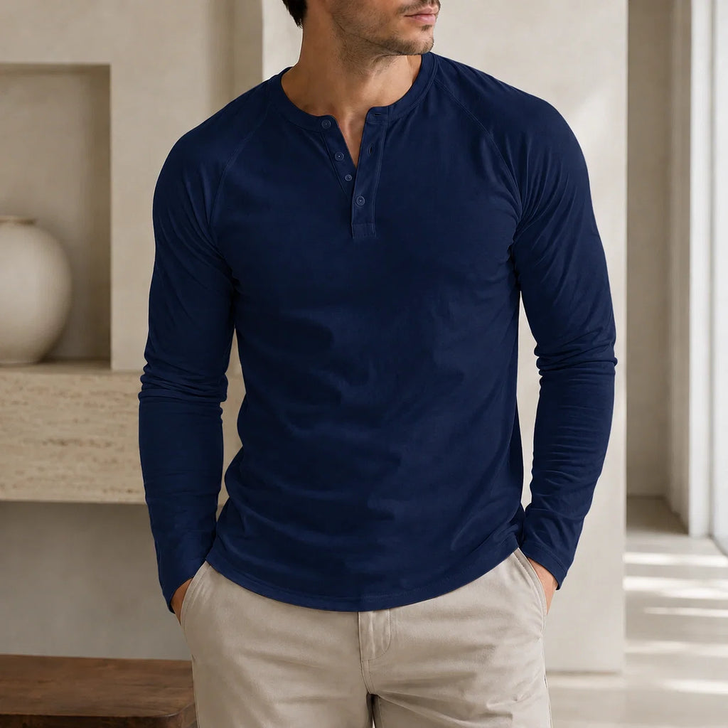 Man wearing a navy blue long-sleeve Henley sweater with a three-button placket, ribbed cuffs, and a classic slim fit.