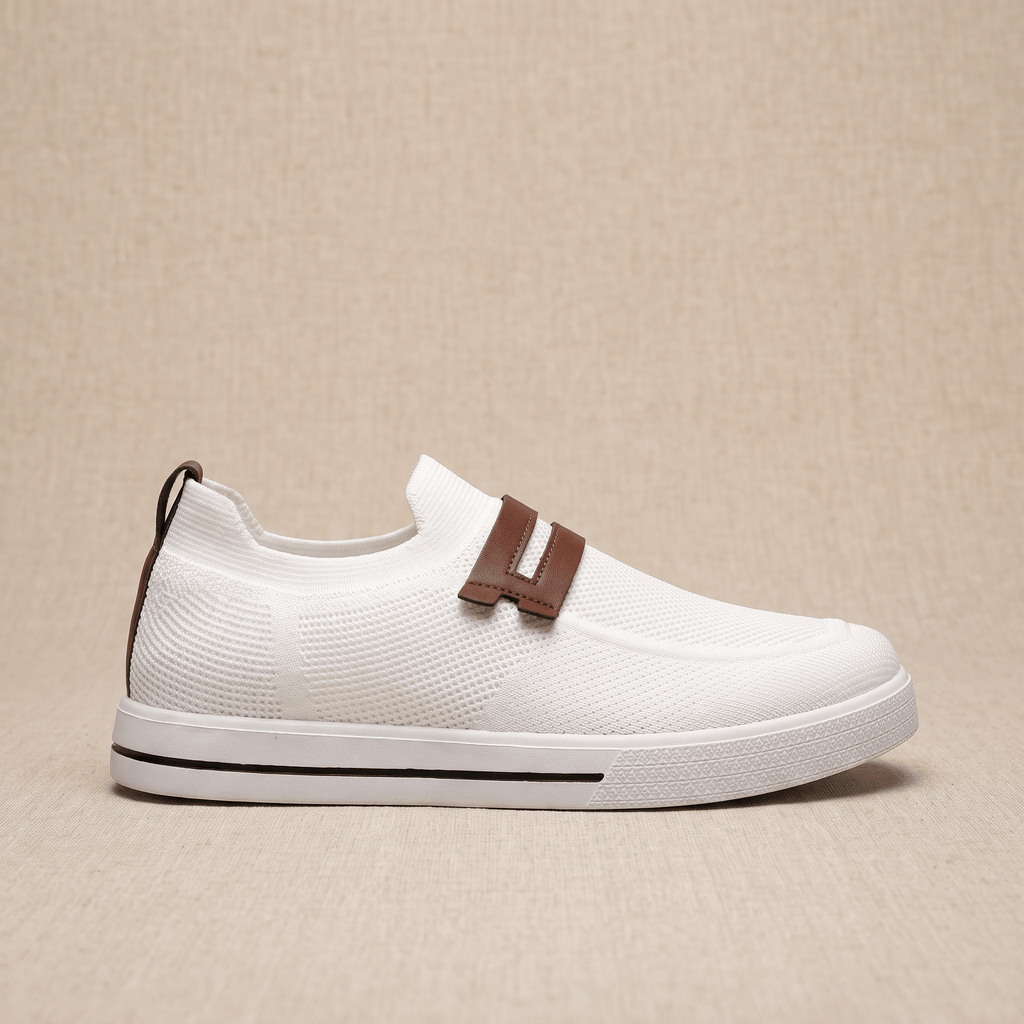 Side profile of a single white mesh Orion sneaker with brown leather strap and pull tab, resting on a beige surface