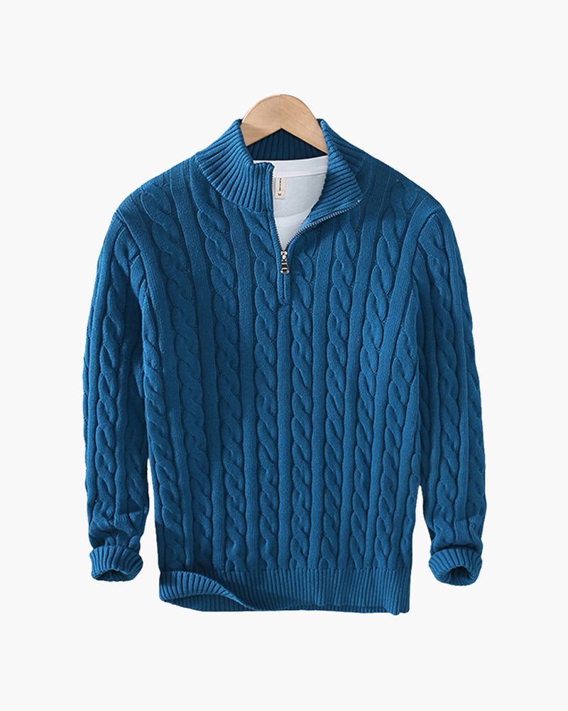 Blue cable knit quarter-zip sweater with a stand collar and ribbed cuffs displayed on a wooden hanger.