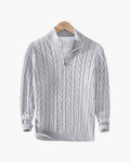 Light gray cable knit quarter-zip sweater with a stand collar and ribbed cuffs displayed on a wooden hanger.