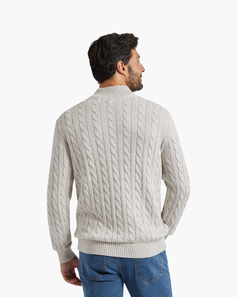 Back view of a light gray cable knit quarter-zip sweater with a stand collar, paired with blue jeans.