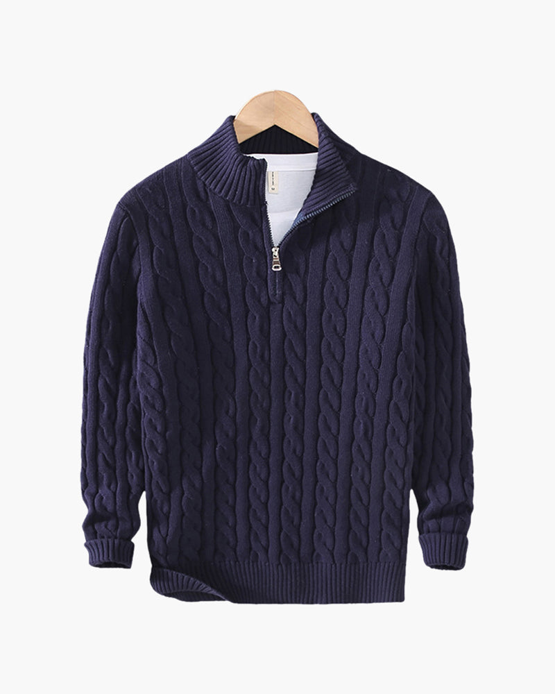 Navy cable knit quarter-zip sweater with a stand collar and ribbed cuffs displayed on a wooden hanger.
