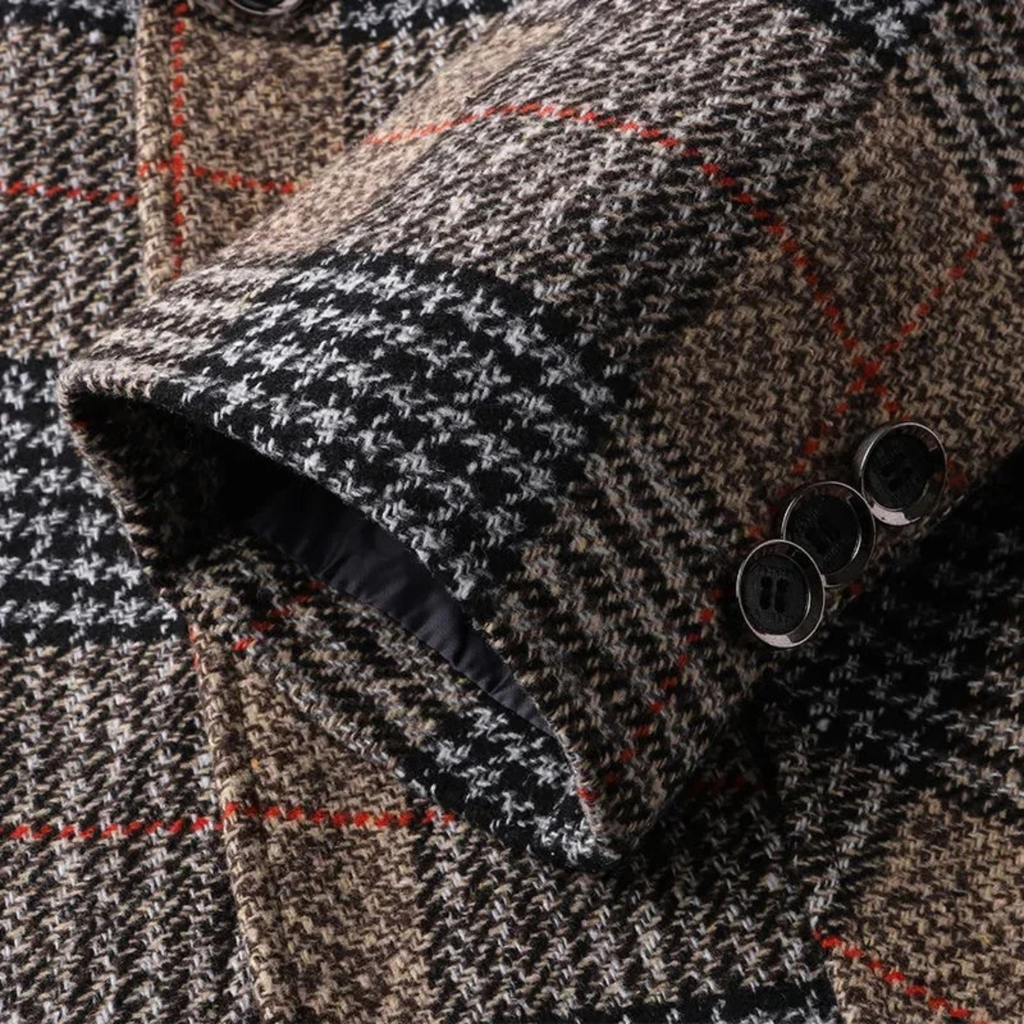 Close-up of the plaid tweed fabric and button cuff detailing on a men's tailored blazer.