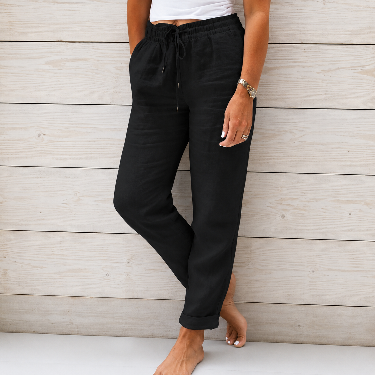 Women's black linen drawstring pants featuring a relaxed tapered fit, elastic waistband, and lightweight breathable fabric.