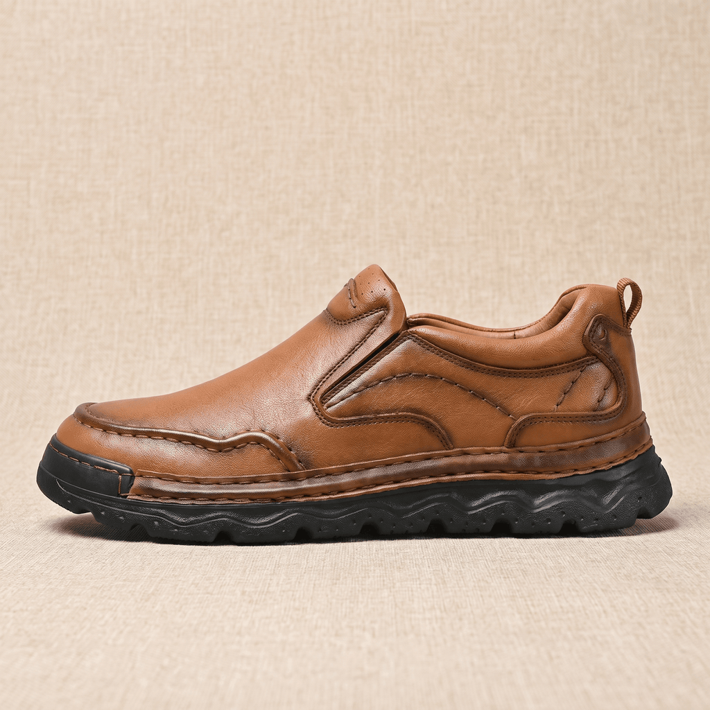 Side profile of a single brown leather Piolo loafer with textured rubber sole, resting on a beige surface