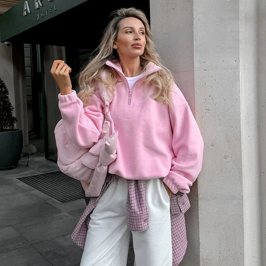 Pink quarter-zip fleece pullover worn by a female model outdoors