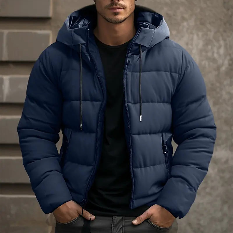 Navy blue quilted puffer jacket with a drawstring hood, full-zip front, and tailored fit worn over a black shirt.
